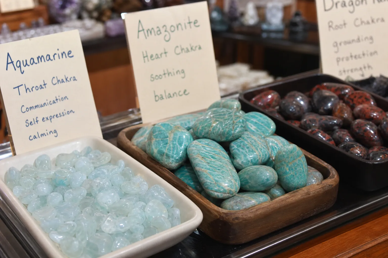 A crystal shop style grouping with aquamarine, veined amazonite, darker stones, and unreadable labels showing how mixed descriptions can combine several symbolic layers